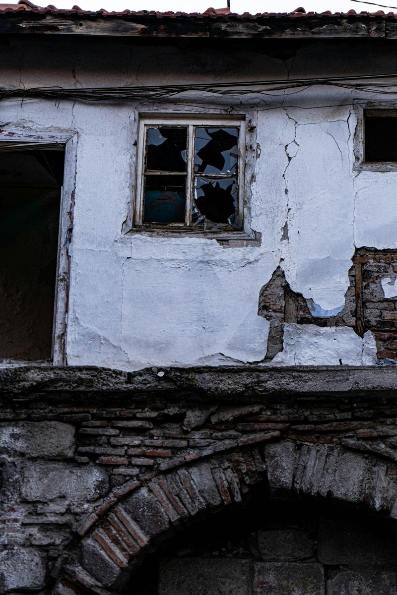 Façade fissurée sous un enduit ancien