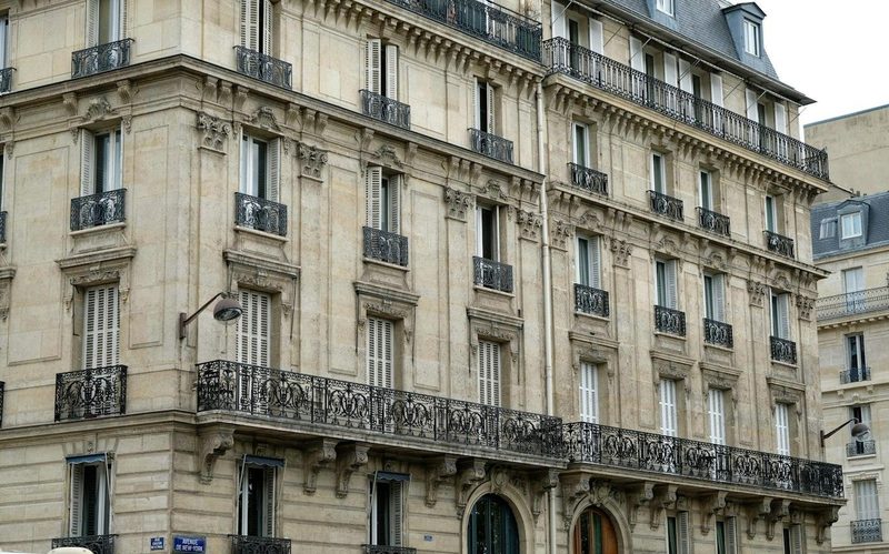 Façade en pierre de taille d'un immeuble haussmannien, balcons en fer forgé